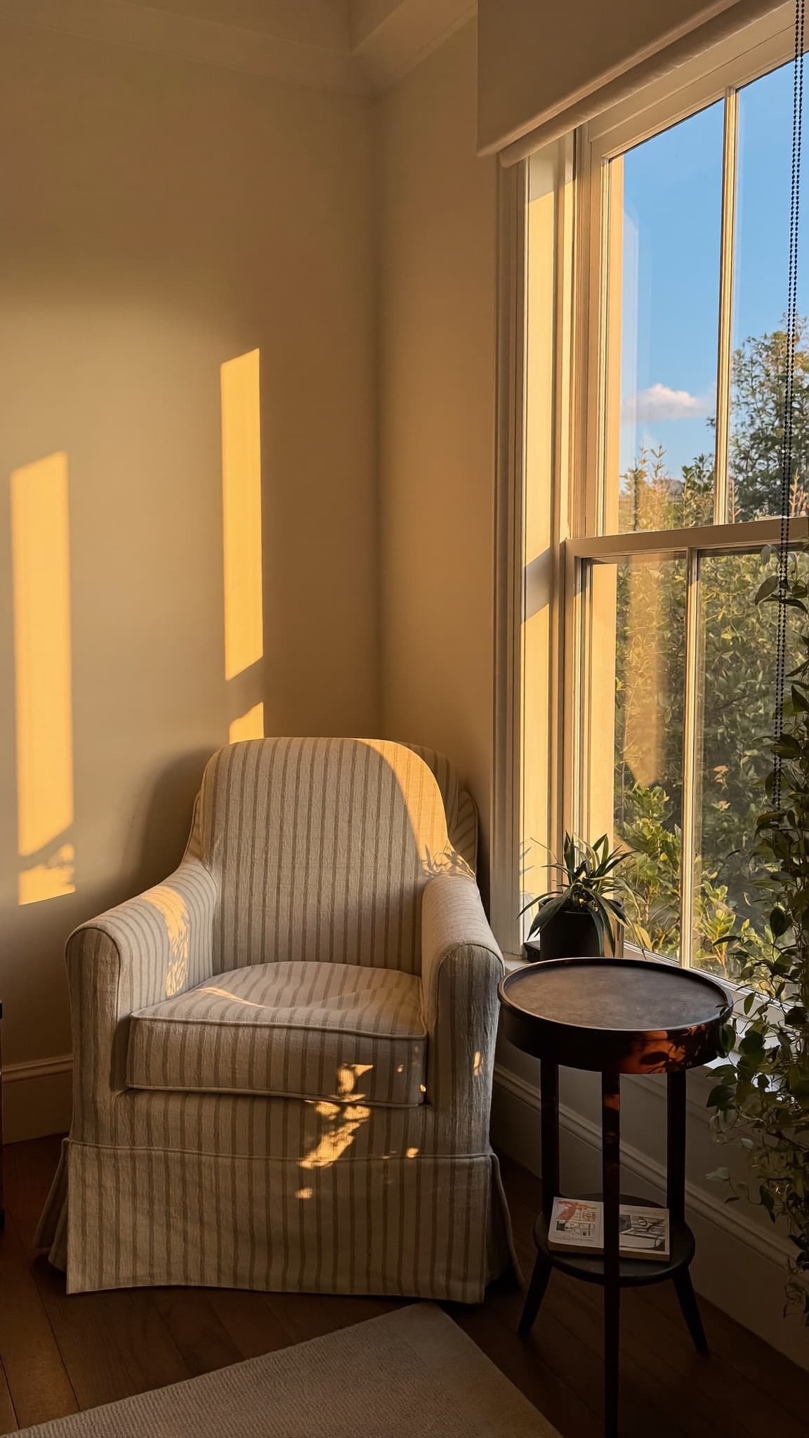 An armchair beside a window in golden evening light