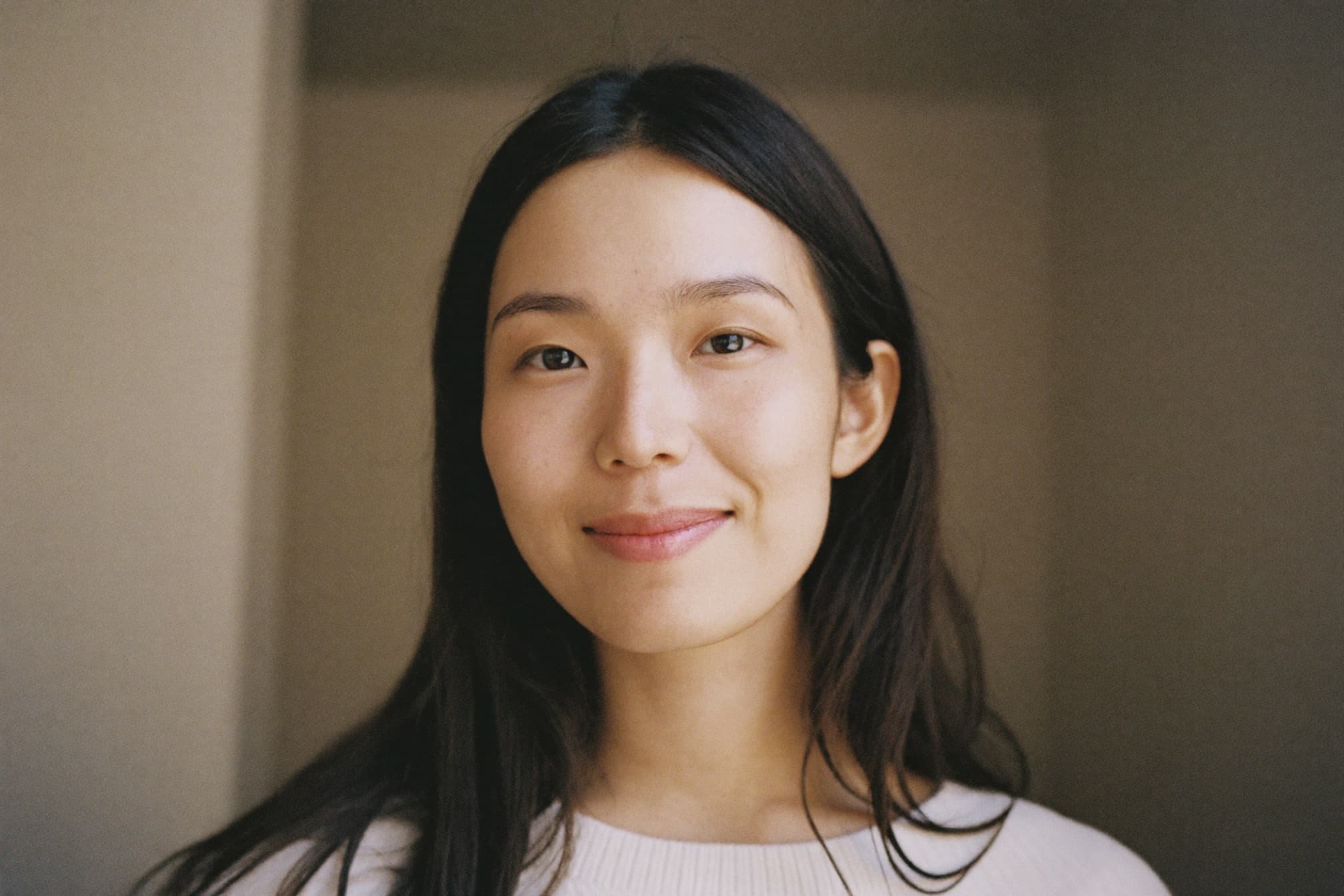 A woman with long hair smiling gently